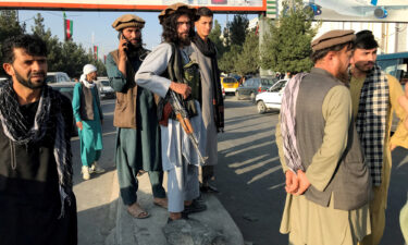 A member of Taliban (C) stands outside Hamid Karzai International Airport in Kabul