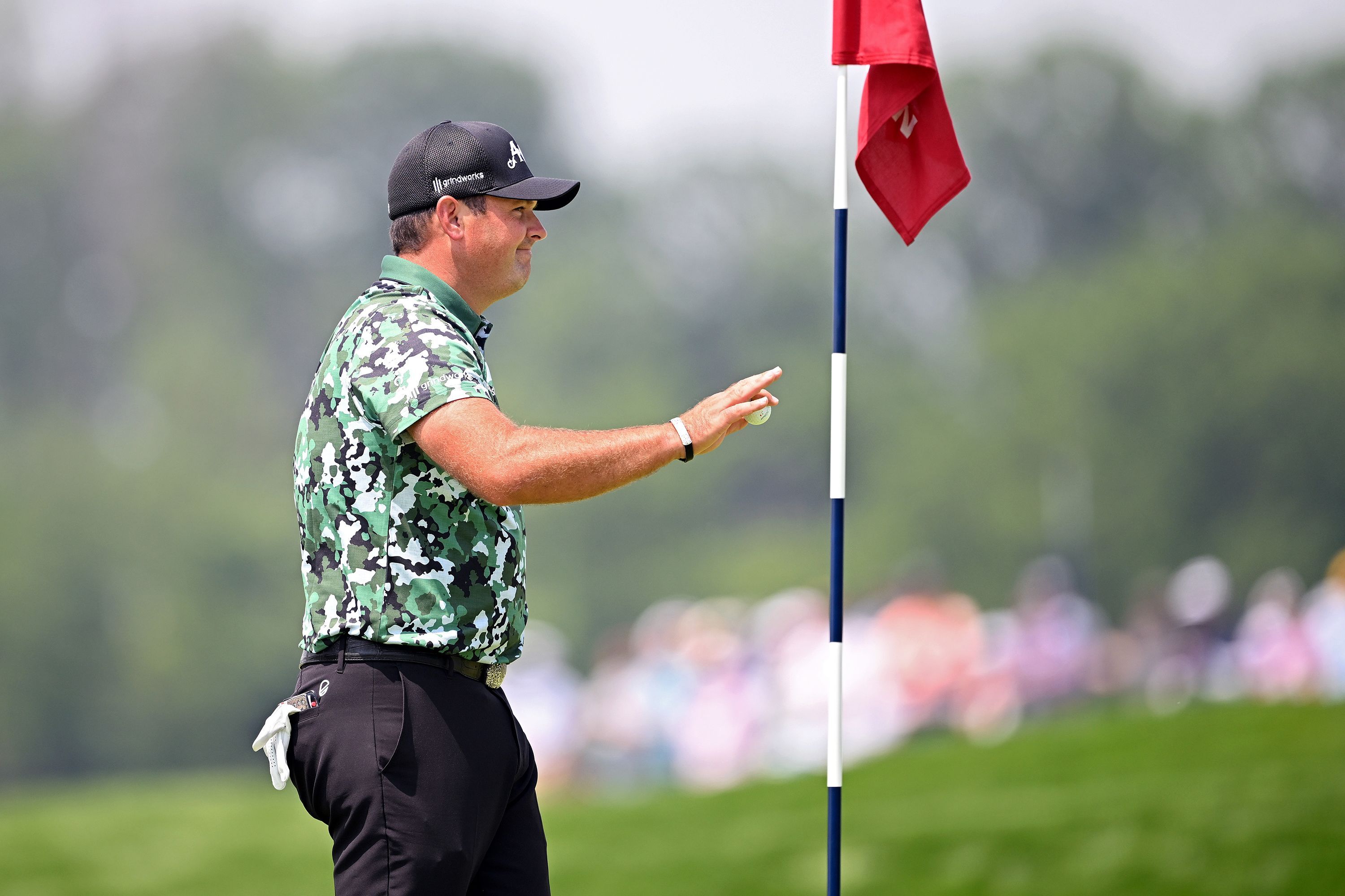 Patrick Reed picks up his ball after carding an albatross on the par-5 fourth at Oakmont Country Club.